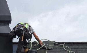 Homeowner inspecting roof shingles from the ground while holding a ladder and binoculars.